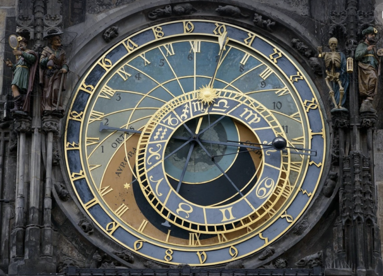 The Prague Astronomical Clock, with ornate gold details, Roman numerals, zodiac signs, and intricate astronomical indicators.